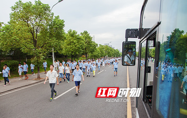 霎時(shí)間淹沒在(zài)一(yī / yì /yí)片藍色的(de)廠服中。員工還可以(yǐ)乘坐免費公交車上(shàng)下班。李磊攝。.jpg
